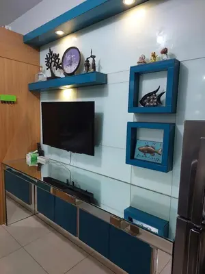 a living room with a tv and a blue wall at Suite 1443D at Shell Residence by GK Condotel in Manila