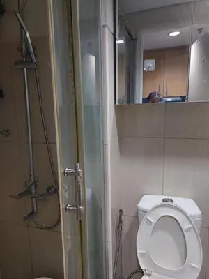 a bathroom with a toilet and a shower and a mirror at Suite 1443D at Shell Residence by GK Condotel in Manila