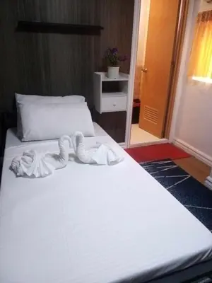 a bedroom with a white bed with a white blanket at furutech hostel in Manila