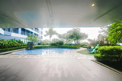 a swimming pool with a slide in a building at Cozy Crash Pad B Laughter friendly Makati 2271 Gym Swim Park 300 in Manila