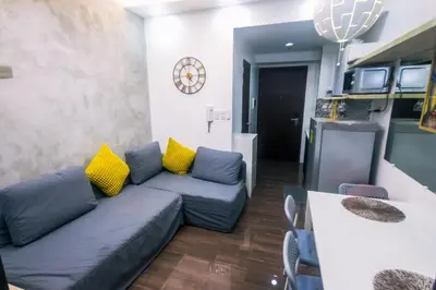 a living room with a blue couch and yellow pillows at Cozy Crash Pad C Laughter Makati 2272 Swim Gym Park Internet 300 in Manila