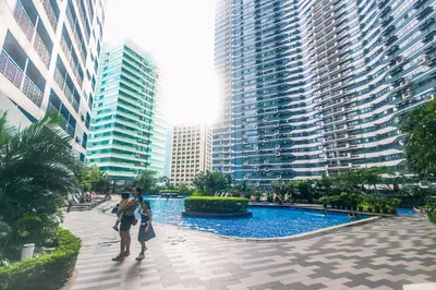 a group of people standing in front of tall buildings at Cozy Crash Pad C Laughter Makati 2272 Swim Gym Park Internet 300 in Manila