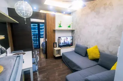 a living room with a couch and a tv at Cozy Crash Pad C Laughter Makati 2272 Swim Gym Park Internet 300 in Manila