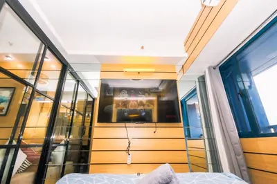 a bedroom with a bed and a glass wall at Hidden Gem Coolest Crash spot Makati Swim Gym Park 2320 in Manila
