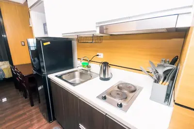 a small kitchen with a sink and a refrigerator at Hidden Gem Coolest Crash spot Makati Swim Gym Park 2320 in Manila