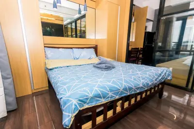 a bedroom with a bed with a blue comforter at Hidden Gem Coolest Crash spot Makati Swim Gym Park 2320 in Manila