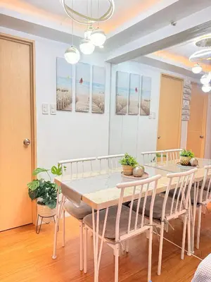 a dining room with a table and chairs at Cozy CondoVibe 2 BR Staycation near SM East Ortigas with Netflix! in Manila