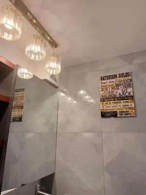 a bathroom with a shower and two chandeliers at Cozy CondoVibe 2 BR Staycation near SM East Ortigas with Netflix! in Manila