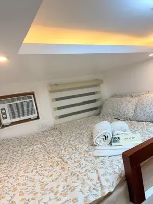 a bedroom with a bed with towels on it at Cozy CondoVibe 2 BR Staycation near SM East Ortigas with Netflix! in Manila
