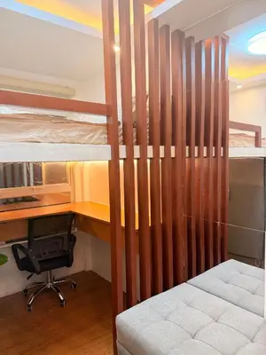 a bedroom with two bunk beds and a desk at Cozy CondoVibe 2 BR Staycation near SM East Ortigas with Netflix! in Manila