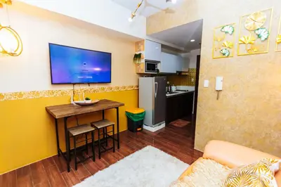 a living room with a table and a tv on a wall at Secret Makati Love Haven Swim Gym Park Laugh 300MB in Manila