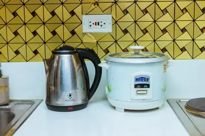 a slow cooker and a tea kettle on a counter at Secret Makati Love Haven Swim Gym Park Laugh 300MB in Manila
