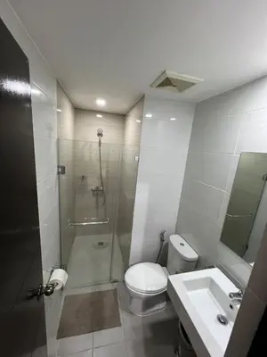 a bathroom with a shower and a toilet and a sink at 101 Newport in Manila