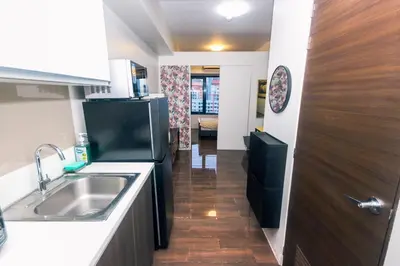 a kitchen with a sink and a refrigerator at Royal Polo club Air condo Makati Swim Gym Park 300 mbps in Manila