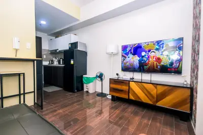 a living room with a large flat screen tv at Royal Polo club Air condo Makati Swim Gym Park 300 mbps in Manila