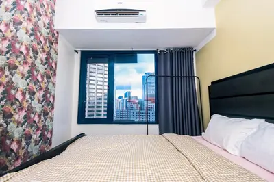 a bedroom with a bed and a window with a view at Royal Polo club Air condo Makati Swim Gym Park 300 mbps in Manila