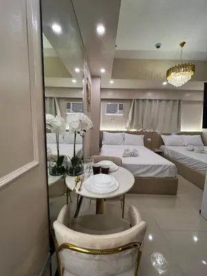 a room with two beds and a table and chairs at Radiance Manila Bay in Manila
