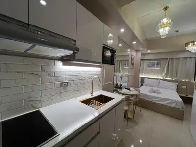 a kitchen with a sink and a bed in a room at Radiance Manila Bay in Manila
