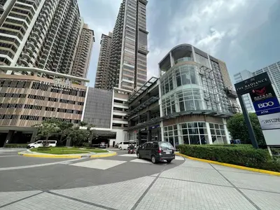 a car driving down a city street with tall buildings at Radiance Manila Bay in Manila