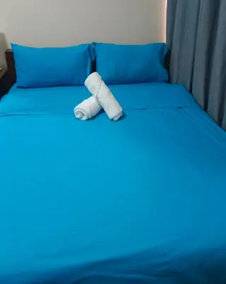 a roll of toilet paper sitting on a bed at BayFront 1BR Condo in Pasay with FREE Wi-Fi, Netflix, Pool Access & Gym, Near NAIA Airport, MOA, OKADA, CCP & PICC in Manila