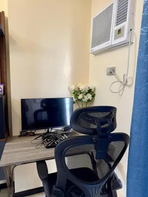 a desk with a computer monitor and a chair at BayFront 1BR Condo in Pasay with FREE Wi-Fi, Netflix, Pool Access & Gym, Near NAIA Airport, MOA, OKADA, CCP & PICC in Manila