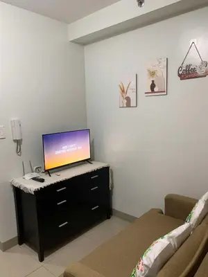 a living room with a flat screen tv on a dresser at VSV Luxury Family Suite staycation Moa shore2 tower2 unit1122 in Manila