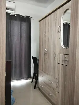 a wooden cabinet with a mirror and a chair in a room at VSV Luxury Family Suite staycation Moa shore2 tower2 unit 1122 in Manila