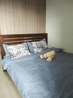 a bed with blue sheets and two pillows on it at VSV Luxury Family Suite staycation Moa shore2 tower2 unit 1122 in Manila