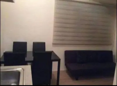 a dining room with a table and chairs and a sink at Laureano di trevi tower 2 Condominium Corporation in Manila