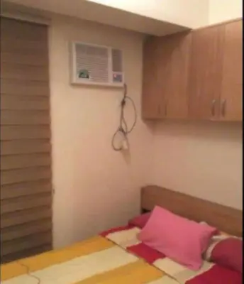 a small room with a bed and a air conditioner at Laureano di trevi tower 2 Condominium Corporation in Manila
