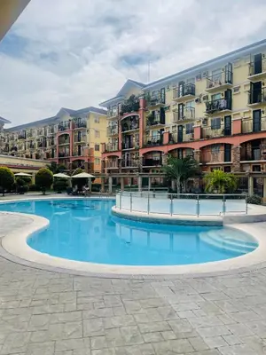 a large swimming pool in front of a building at Cozy 1 Bedroom Unit Arezzo Place Pasig in Pasig