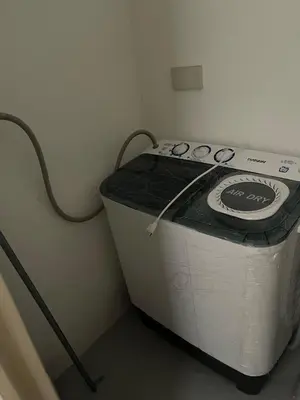 a washing machine sitting in a corner of a room at Cozy 1 Bedroom Unit Arezzo Place Pasig in Pasig
