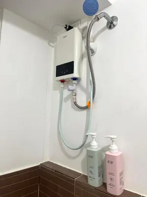 a shower in a bathroom with two bottles of soap at Cozy 1 Bedroom Unit Arezzo Place Pasig in Pasig