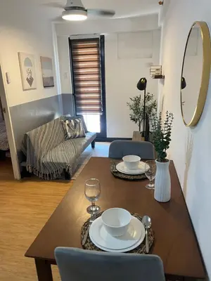 a living room with a table and a couch at Cozy 1 Bedroom Unit Arezzo Place Pasig in Pasig