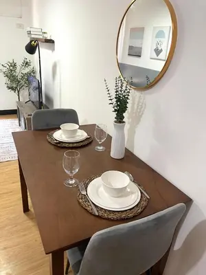 a dining room table with a mirror on the wall at Cozy 1 Bedroom Unit Arezzo Place Pasig in Pasig