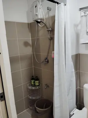 a bathroom with a shower with a toilet at Condo sa south residences tower 3 in Manila