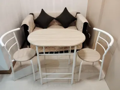 a table and chairs in a room with a couch at Condo sa south residences tower 3 in Manila