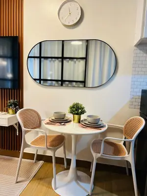 a white table with chairs and a round mirror at CityZen Suite in Trece Martires