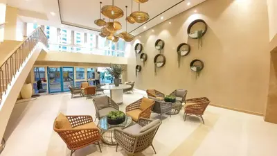 a lobby with chairs and tables and mirrors on the wall at LUXX Suites McKinley with fast WIFI in BGC in Manila