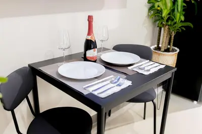 a black table with two glasses and a bottle of wine at LUXX Suites McKinley with fast WIFI in BGC in Manila