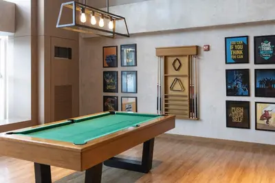 a pool table in a room with pictures on the wall at LUXX Suites McKinley with fast WIFI in BGC in Manila