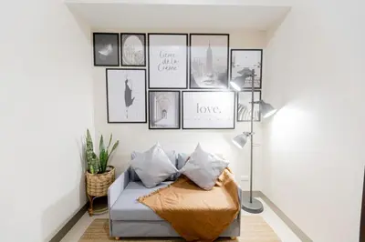 a living room with a couch and pictures on the wall at LUXX Suites McKinley with fast WIFI in BGC in Manila