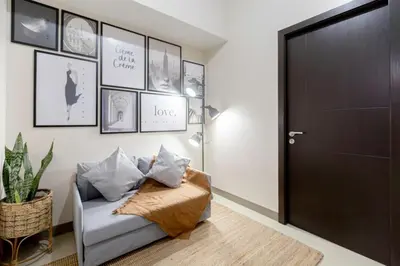 a living room with a couch and a black door at LUXX Suites McKinley with fast WIFI in BGC in Manila
