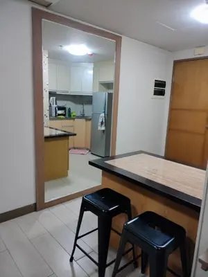 a kitchen with a counter and two stools and a mirror at Room Near Naia Terminal 3 and New World Resort in Manila