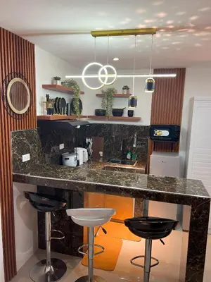 a kitchen with a granite counter top and stools at La Nikolina, Cozy Studio near MOA, CCP & Star City, Pasay in Manila