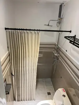 a bathroom with a shower curtain and a toilet at La Nikolina, Cozy Studio near MOA, CCP & Star City, Pasay in Manila