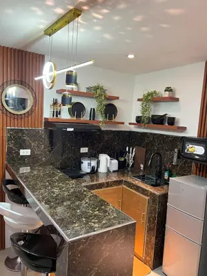 a kitchen with a granite counter top and a sink at La Nikolina, Cozy Studio near MOA, CCP & Star City, Pasay in Manila