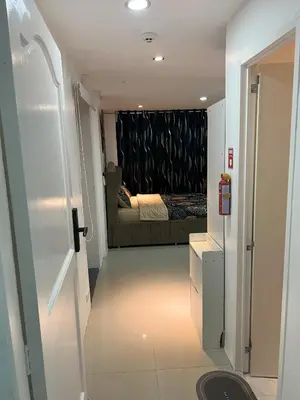 a hallway leading to a bedroom with a bed at La Nikolina, Cozy Studio near MOA, CCP & Star City, Pasay in Manila