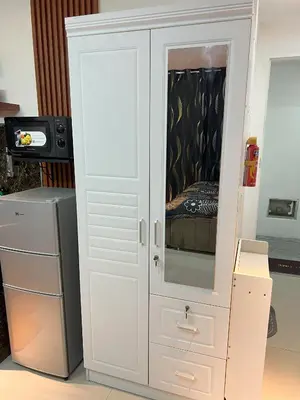 a white cabinet with a mirror in a room at La Nikolina, Cozy Studio near MOA, CCP & Star City, Pasay in Manila