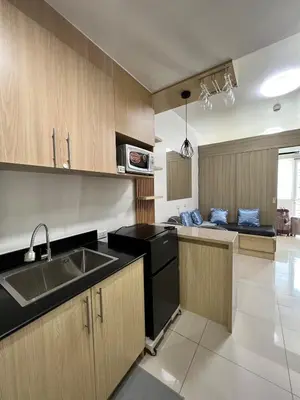 a kitchen with wooden cabinets and a sink at D Crib at Breeze Residences Pasay City Philippines in Manila